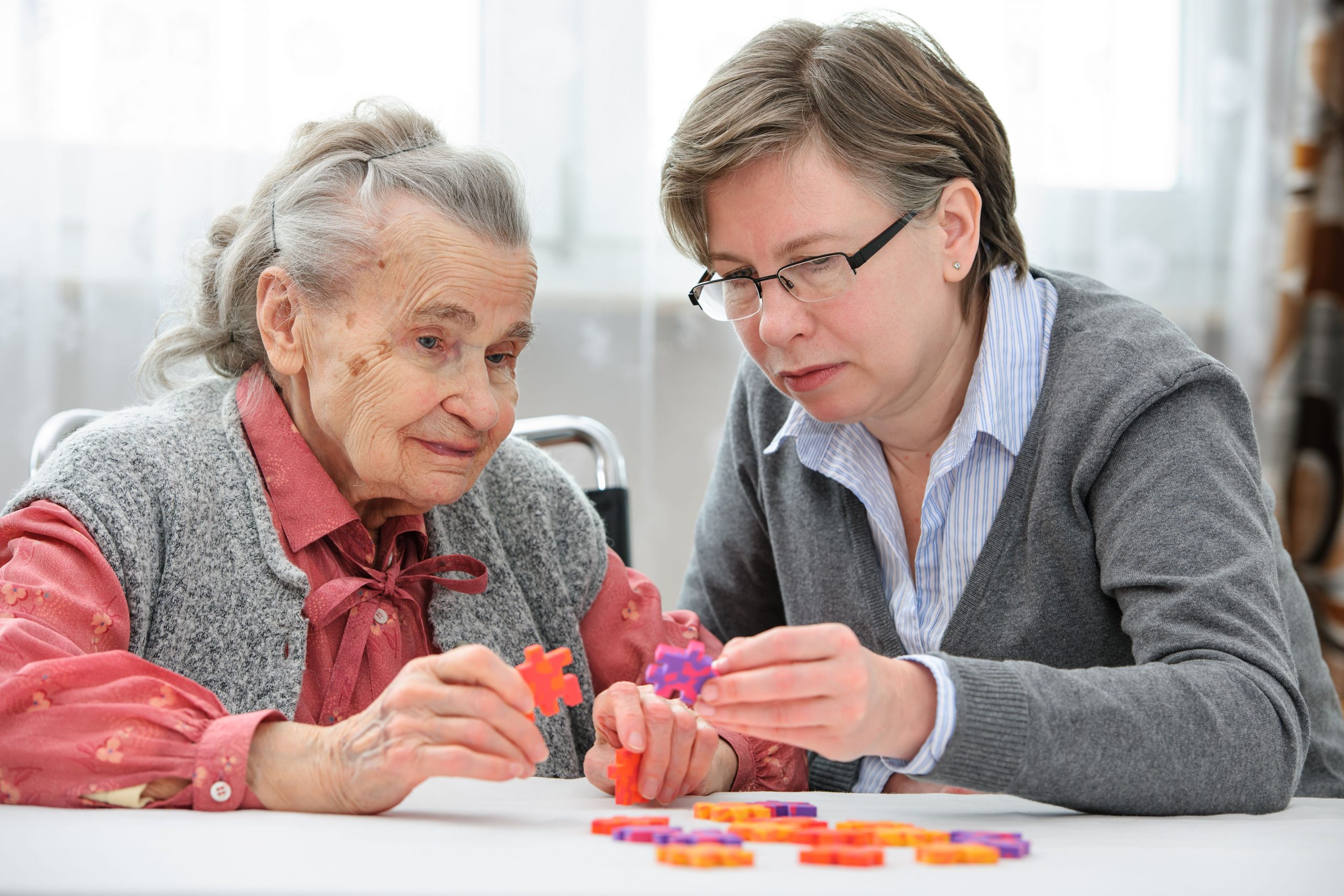 Dementia care trainee working with Alzheimer's patient through skill-building tools gained from dementia care workshop.